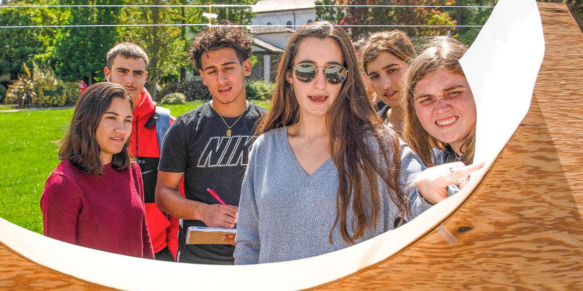 Students examine object during outdoor class