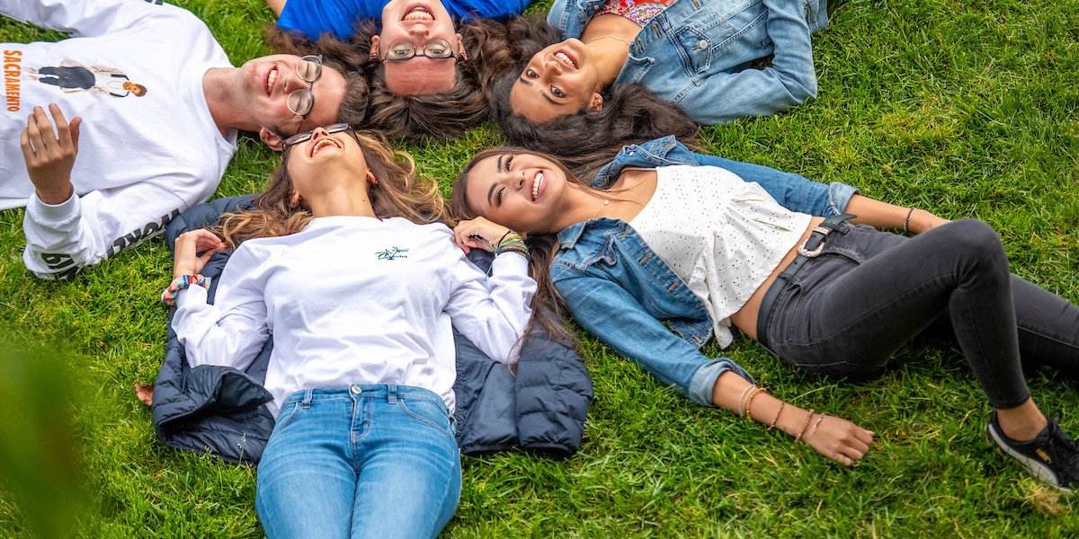 Students laying down together in a star formation