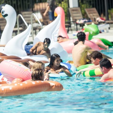 Students on floaties at the pool