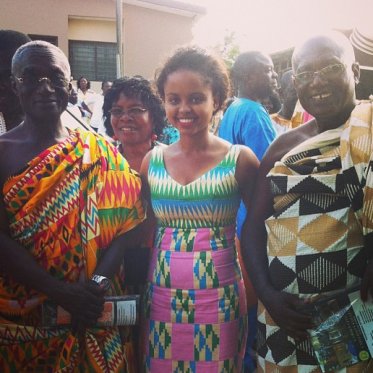 young woman standing between two older people