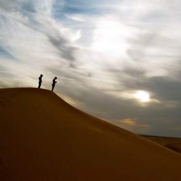 two people at a great distance standing at the top of a hill