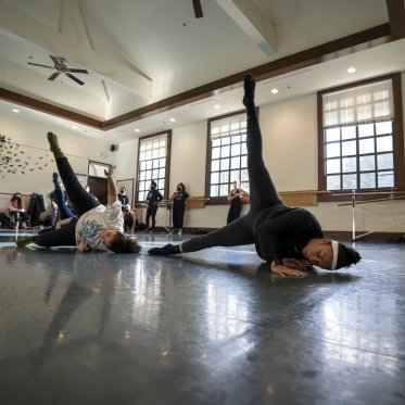 Dancers on sides with legs raised