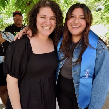 two women standing and smiling