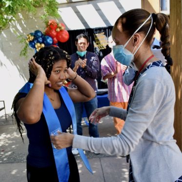 girl helping other girl to wear stole
