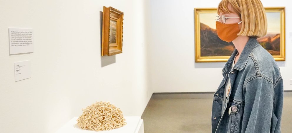 A student is looking at a painting at the MoA SMC