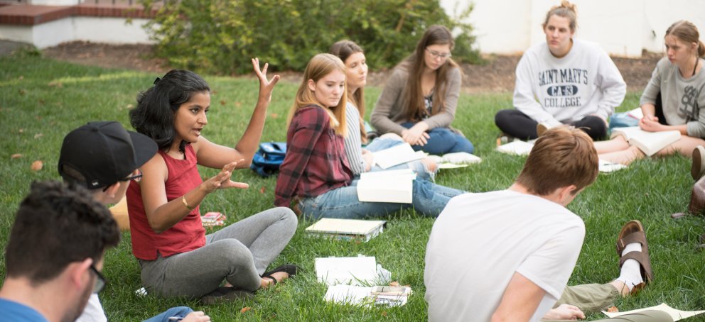 A professor teaching a Shakespeare class outside on the grass