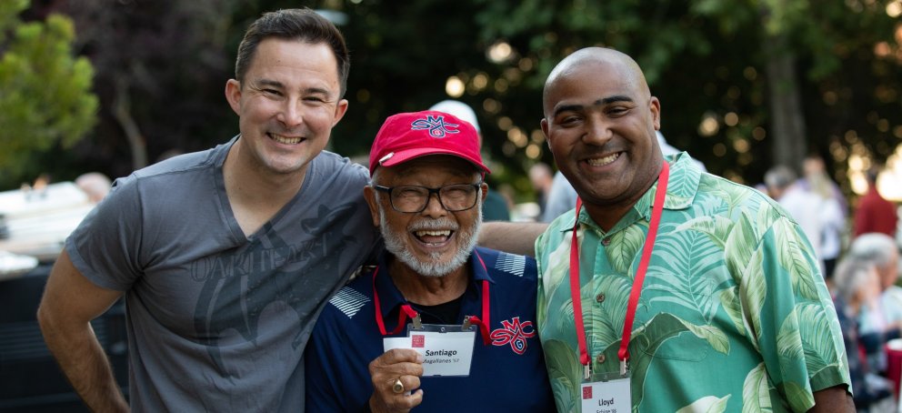 Three people smile at the camera