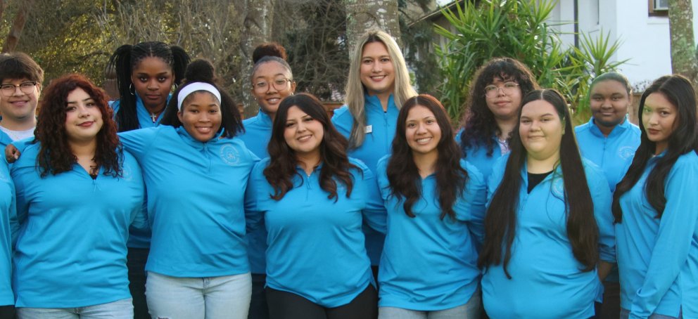 Pictures of staff members comprising the Intercultural Center all wearing blue quarter zips