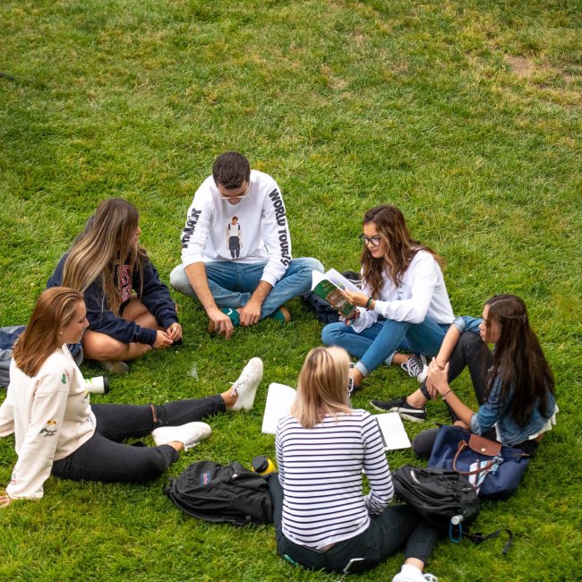 Students sit in circle outside