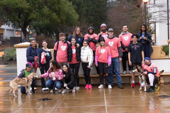 SWEAT: Participants gather together with rescue pups from Contra Costa Animal Services to take a group photo with rescue dogs Bailey (left) &amp; Freesia (right) after the jog around campus.  / Photo by Rebecca Harper