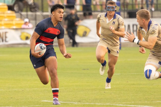 Men's rugby player Sosaia Pongi runs with the ball while Navy defenders chase him in 2024 National Championship