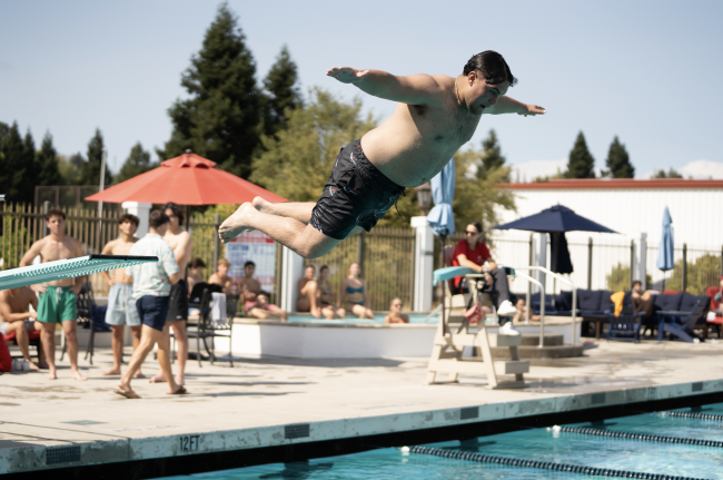 Painfully Rewarding: Diego Christerna ‘28 spreads his arms out wide with his belly ready to smack the water while jumping off the diving board to earn a spot in the Belly Flop Club. / Photo by Francis Tatum
