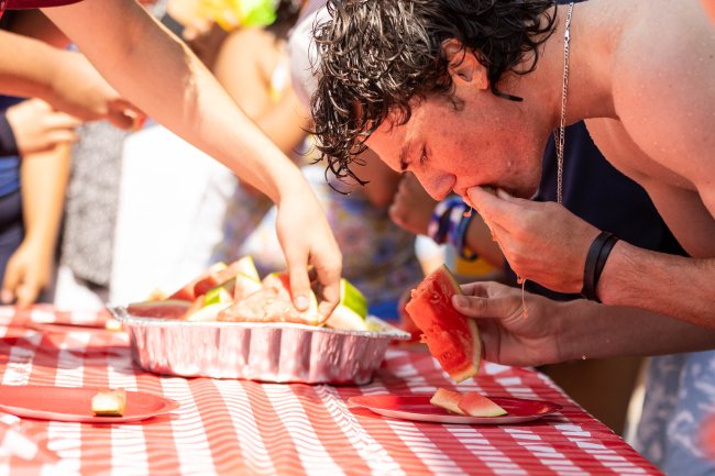 Juicy Mess: First Year student Ian Armstrong ‘28 attempts to eat the most amount of watermelon during the contest at the Weekend of Welcome Pool Party. / Photo by Rebecca Harper