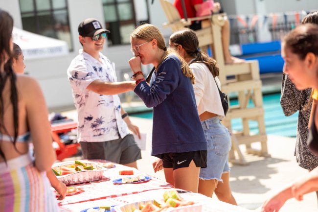 Containing Giggles: Ava Luczkow ‘28 can’t help but laugh at the effort put forth eating watermelon as fast as she could during the eating contest. / Photo by Rebecca Harper