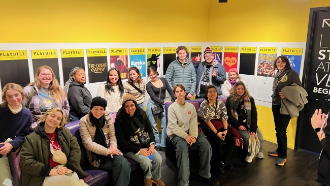 Students in front of a series of Broadway posters