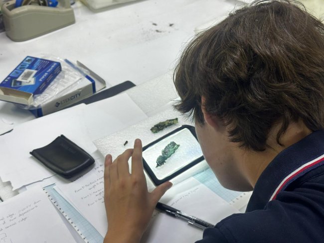 Chris Baker studying an artifact in Turkey, using magnifier