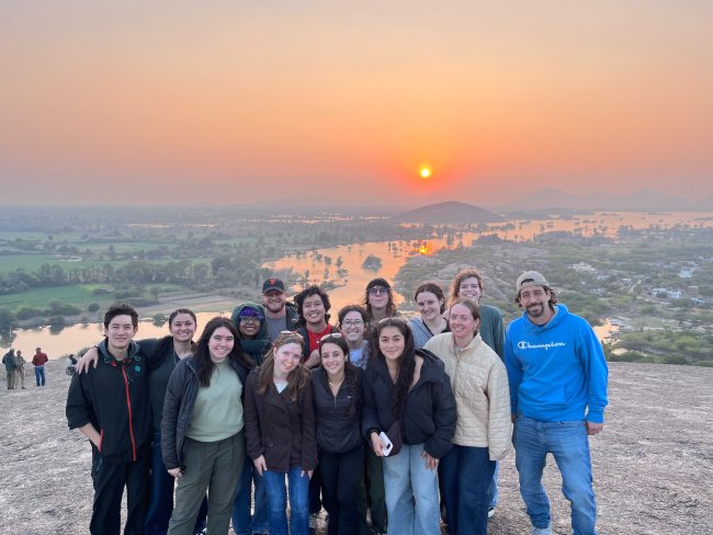 Group of students in front of a sunset in india