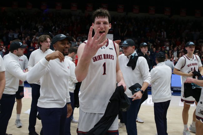 Men's Basketball player Harry Wessels holds up four fingers to celebrate four championships in a row in February 2026