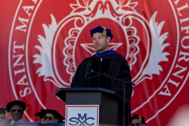 Matthew Dellavedova '13 speaks at 2026 Commencement with SMC seal in the background