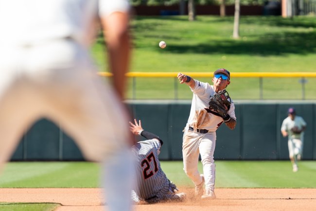 Baseball player Cody Kashimoto tags second base and throws to first in 2026 WCC Tournament