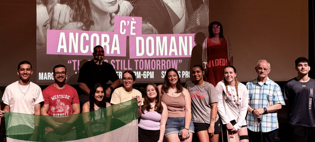 Dante Italian club students standing in front of a movie screen for their film event