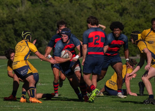 Gael rugby player carries ball while UC Santa Cruz defenders try to stop him