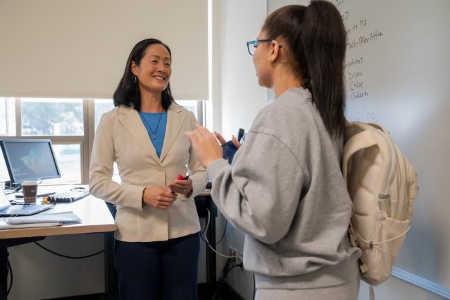 Student on right with Professor Chi-An Emhoff on left, talking