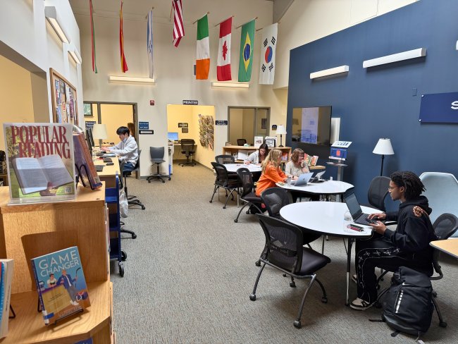 The library at the Power Plant Lobby showing three tables with students sitting at them