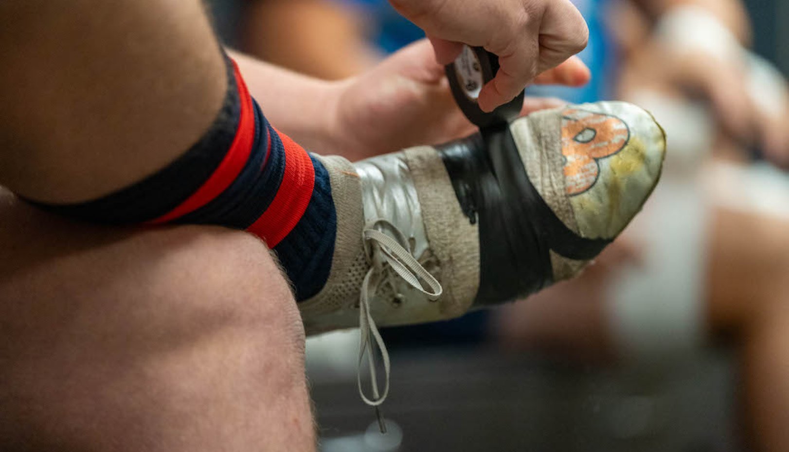 A Gaels rugby player tapes up his shoes before 2024 National Championship