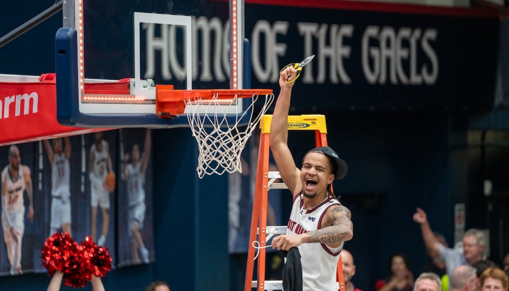 basketball player Mikey Lewis cuts down the net after winning WCC Championship in 2026