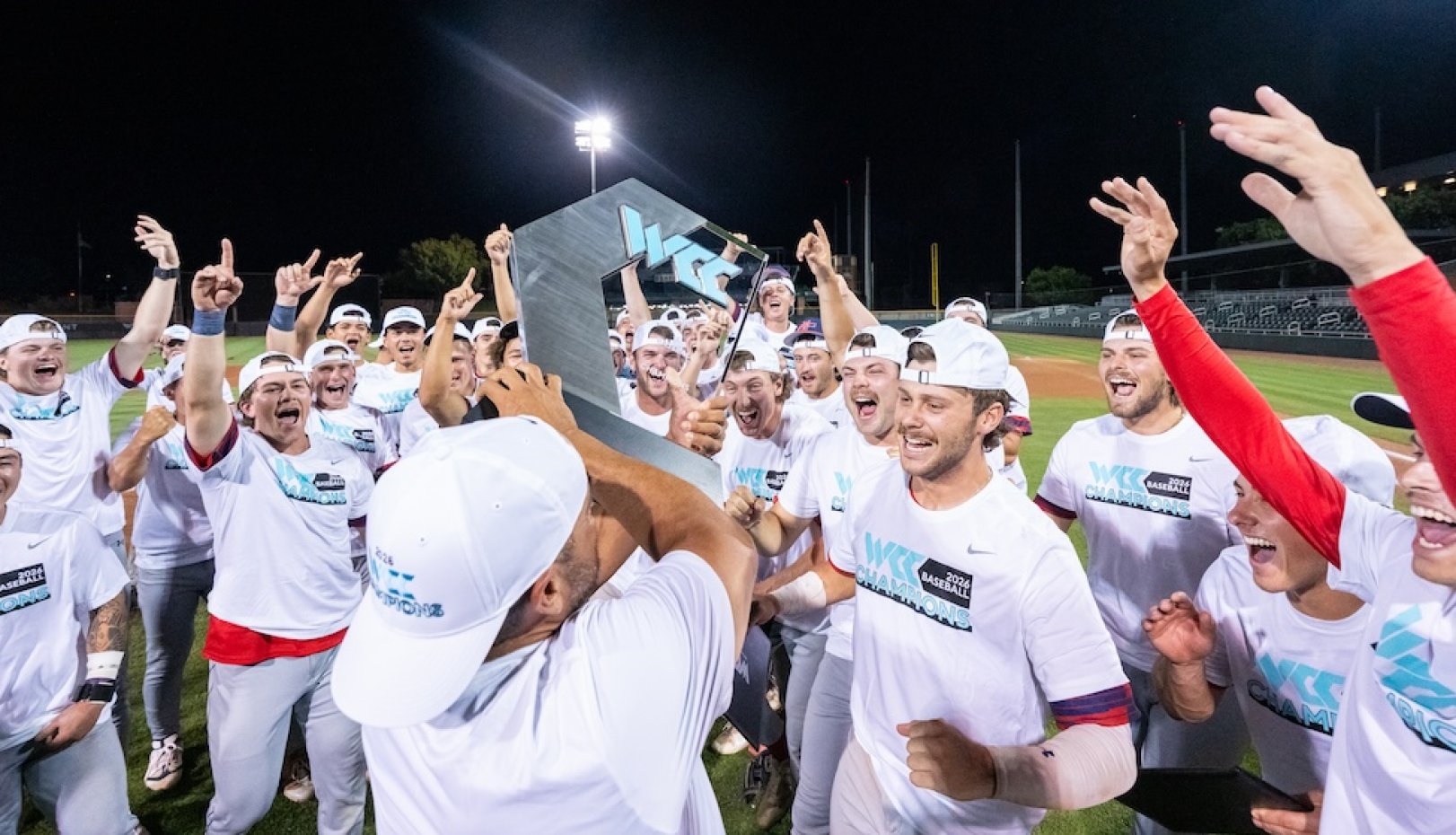 Baseball team cheers and holds 2026 WCC Championship trophy