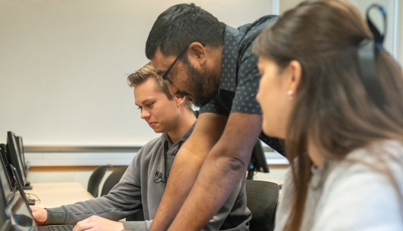 Udayan Das instructing two Computer Science students