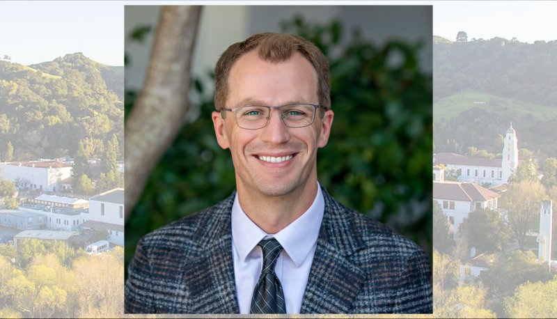 Business faculty member Grant Rozeboom with screened-in image of campus behind him
