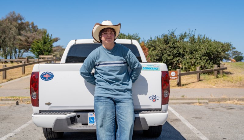 Jesse Ramirez posing in cowboy hat by truck