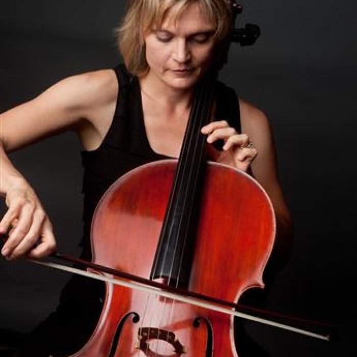 A picture of Anne Lerner-Wright playing a cello against a non-descript background.