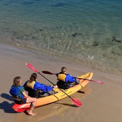Students in a kayak on the shore learning to paddle