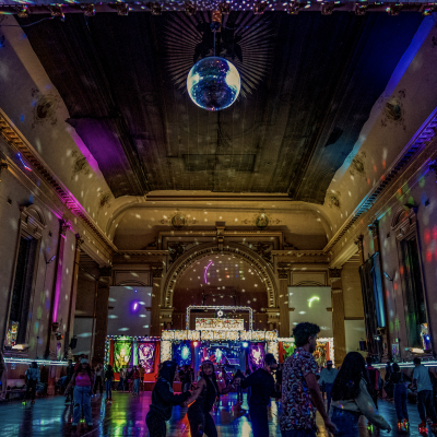 Participants roller skate at the Church of 8 Wheels with a view of the altar as the disco ball shimmers lights around the historic architecture. / Photo By Francis Tatem.