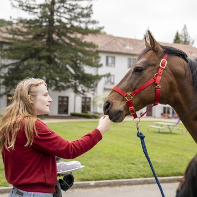 Student with Bart the horse on campus
