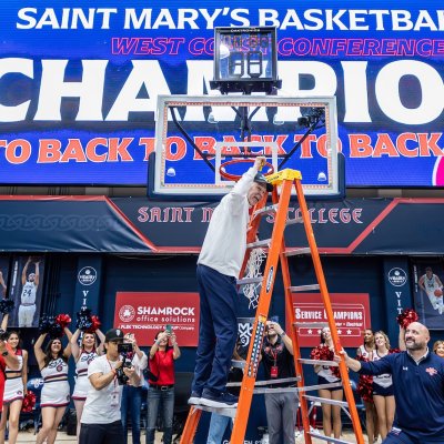 Sign saying Saint Mary's Basketball Champions and coach Randy Bennett with players and spirit team