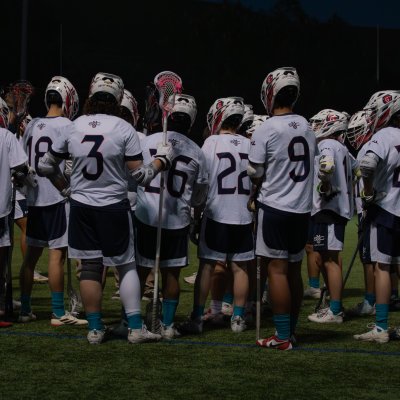 Men's Lacrosse team gathers in a huddle
