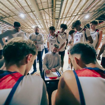Mickey McConnell draws up a play in a huddle of men's basketball players