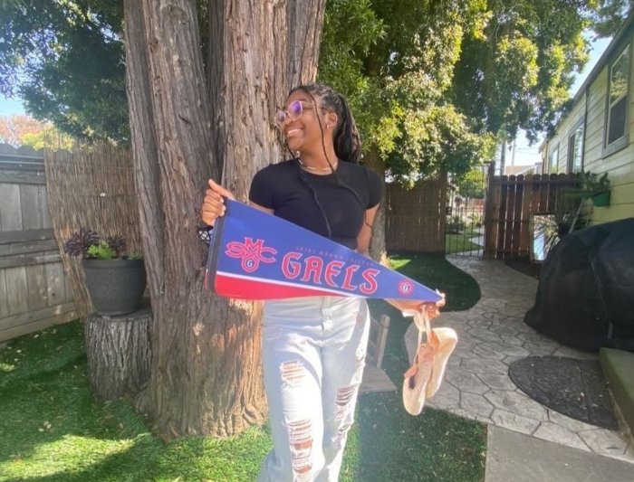 A young woman holds a Saint Mary's pennant