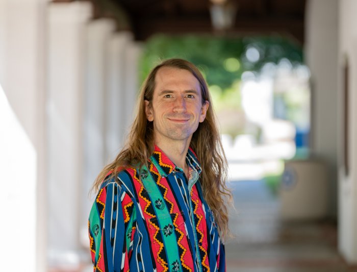 Headshot photo of man standing in corridor